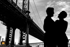 Silhouette of a couple standing face to face after family portraits at iconic DUMBO in New York City.